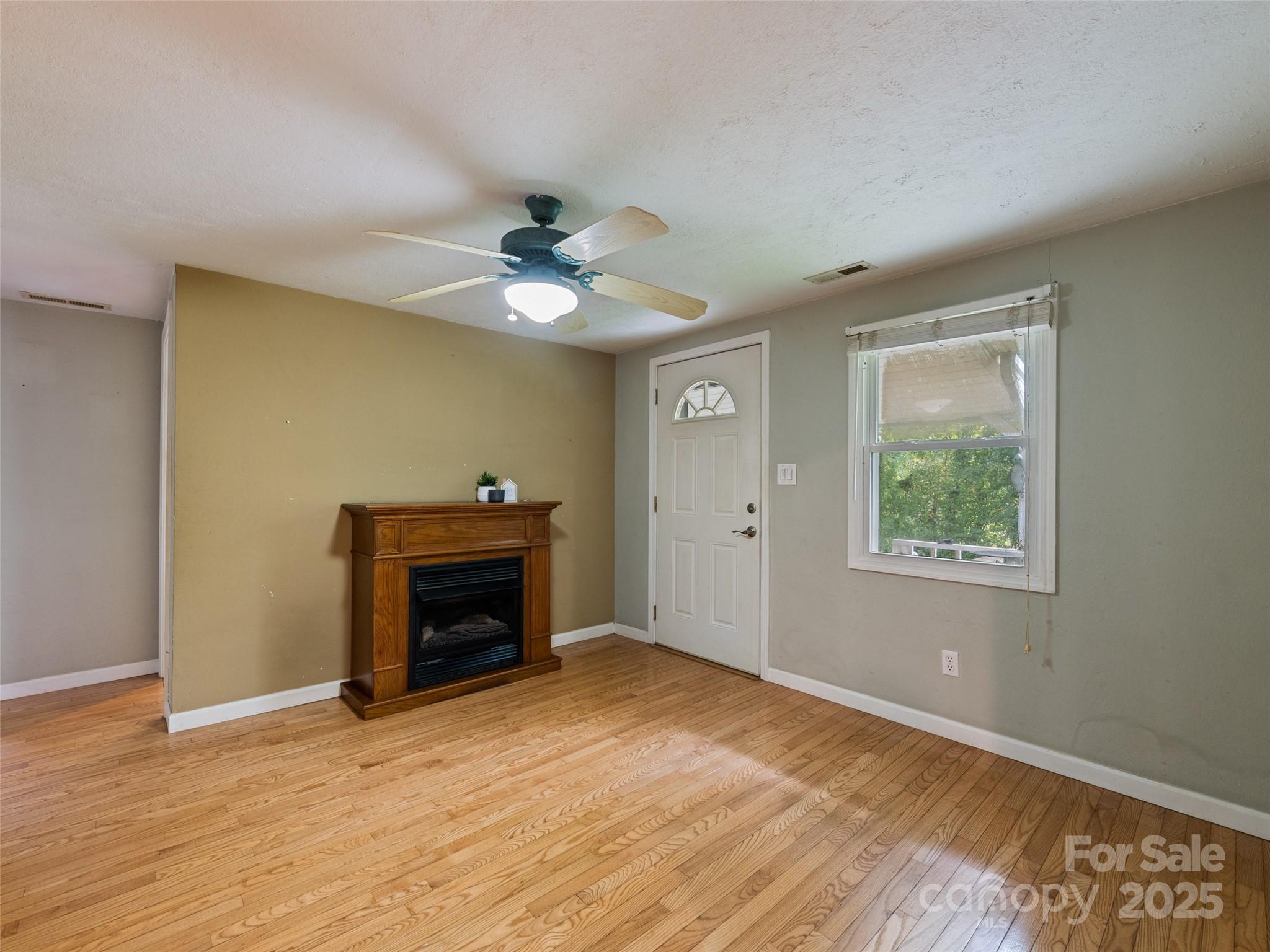 3383 Thickety Road Clyde, NC 28721 - Photo 12 of 33 a view of an empty room with a fireplace and a window