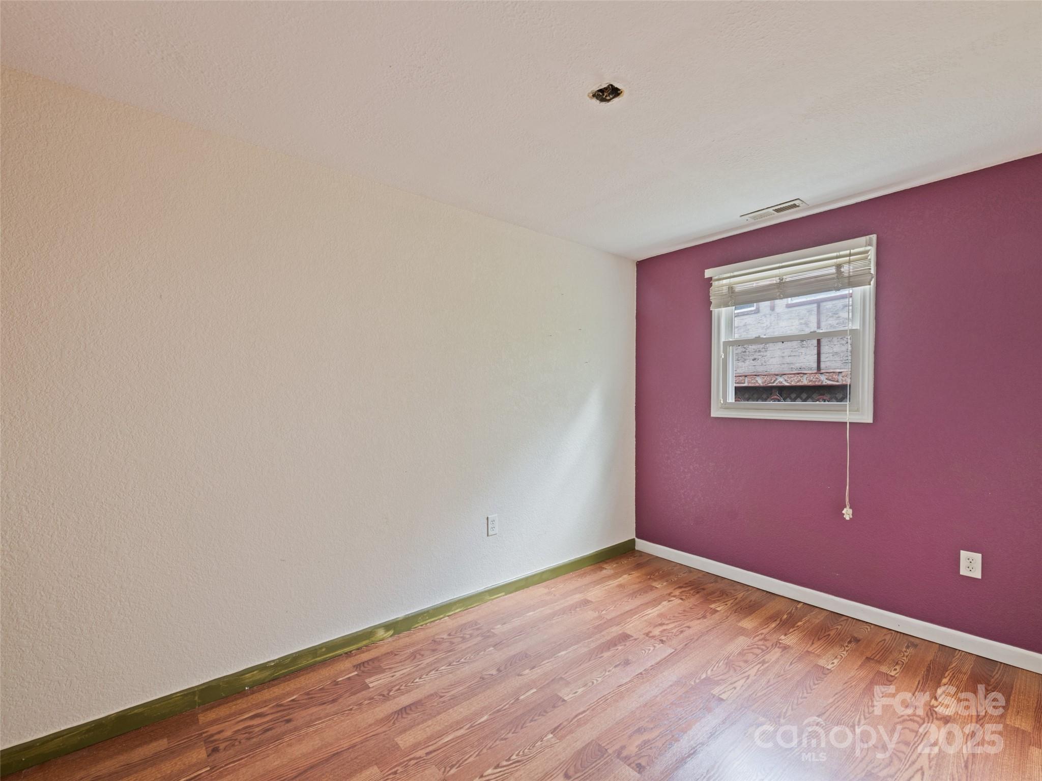 3383 Thickety Road Clyde, NC 28721 - Photo 19 of 33 a view of an empty room with wooden floor and windows