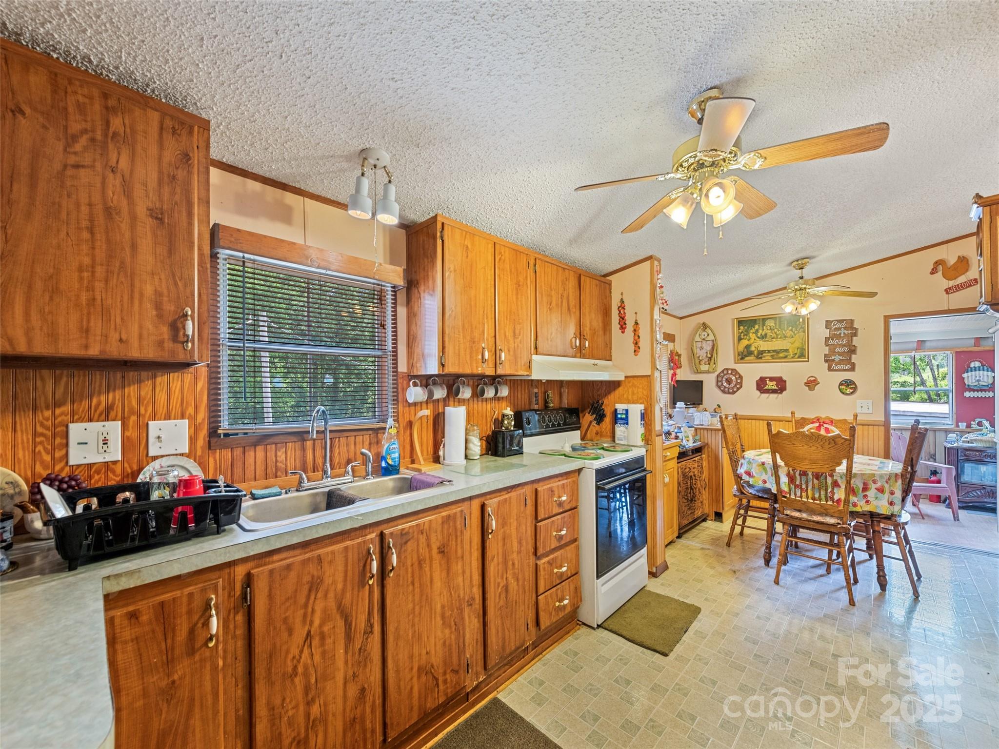 3383 Thickety Road Clyde, NC 28721 - Photo 25 of 33 a kitchen with stainless steel appliances a dining table chairs sink and cabinets