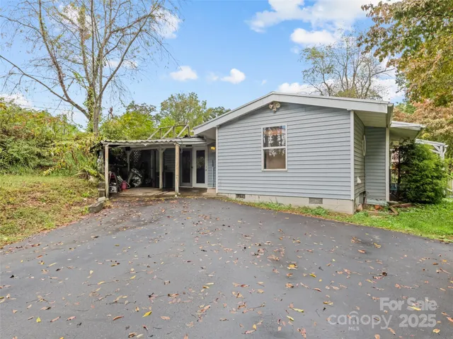 a view of a house with a yard and large tree