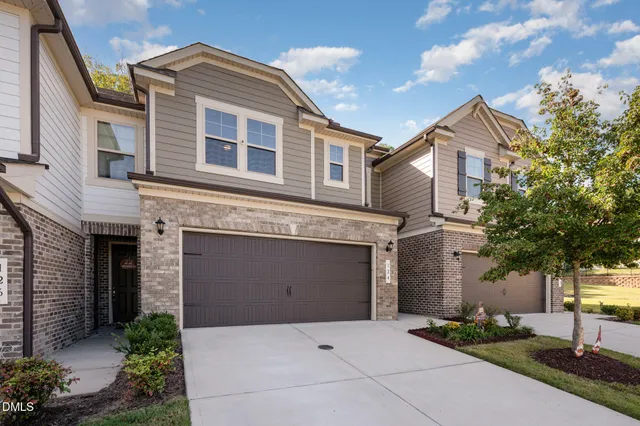 a front view of a house with a garden and plants