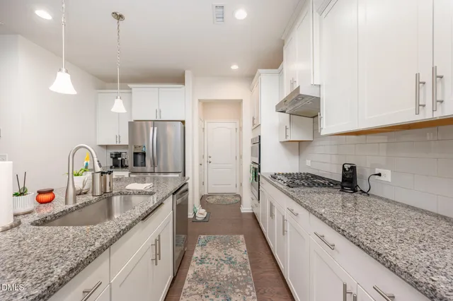 a kitchen with stainless steel appliances granite countertop a sink stove and refrigerator
