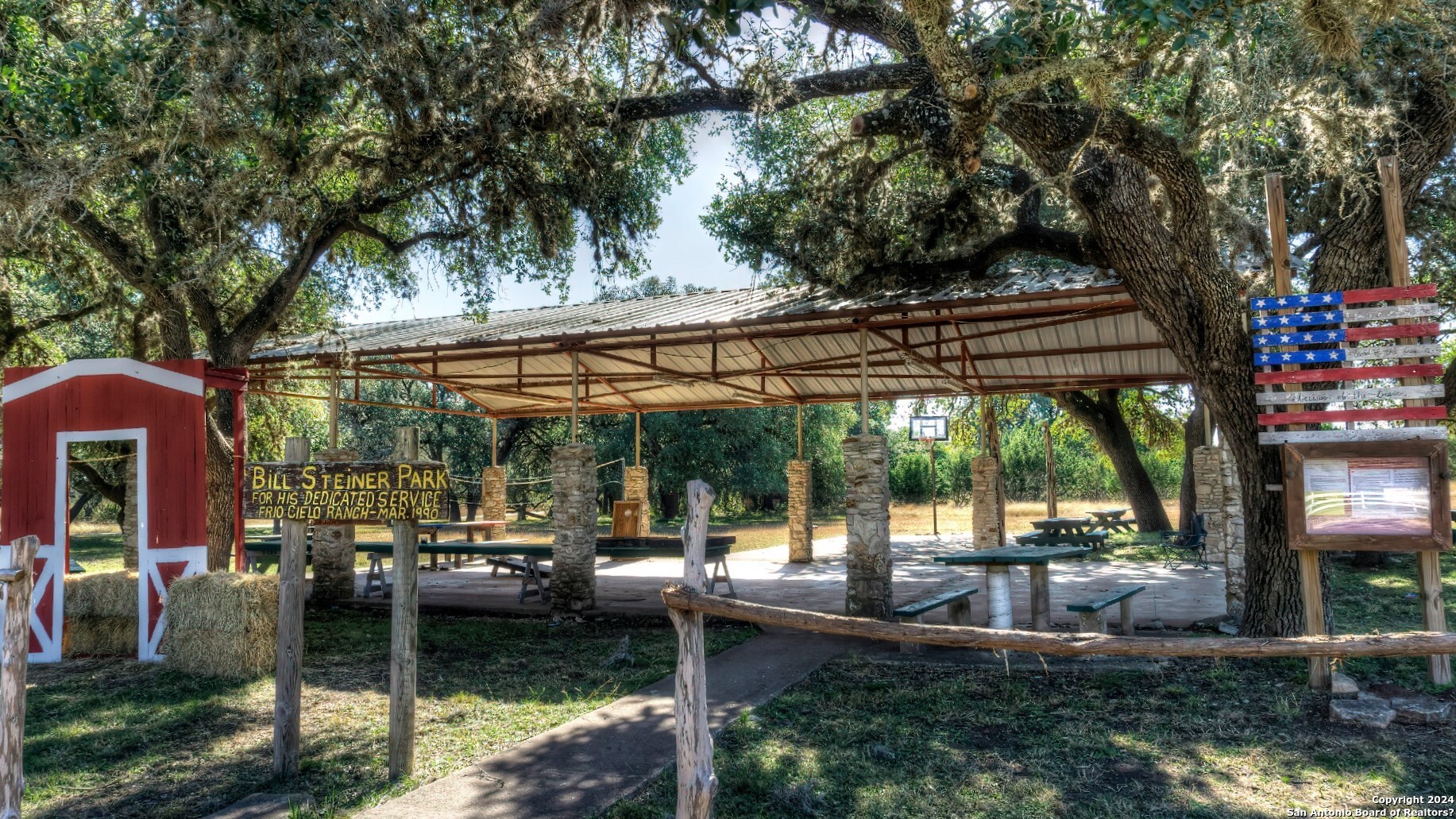 22 Squirrel Bend Uvalde, TX 78801 - Photo 42 of 47 a view of a patio with table and chairs under an umbrella with large trees