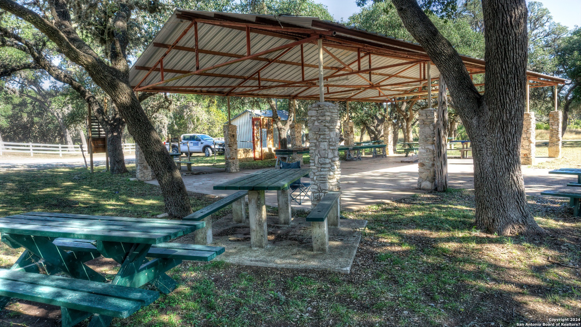 22 Squirrel Bend Uvalde, TX 78801 - Photo 44 of 47 a view of a patio with table and chairs under an umbrella with large trees