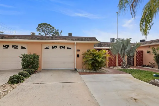 a view of a house with a yard and a palm tree