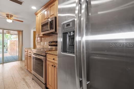 146 Boca Ciega Point Boulevard South, Unit 146 St. Petersburg, FL 33708 - Photo 7 of 14 a kitchen with stainless steel appliances granite countertop a refrigerator a stove and a wooden floors