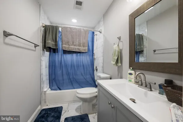 a bathroom with a sink toilet a mirror and shower