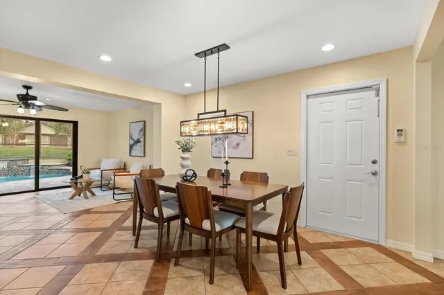 a dining room with furniture a chandelier and wooden floor