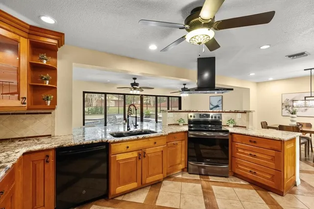 a kitchen with stainless steel appliances granite countertop a sink and a stove