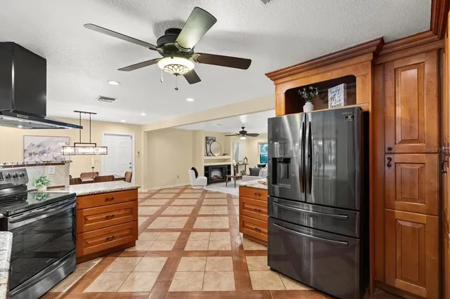 a kitchen with stainless steel appliances kitchen island granite countertop a refrigerator oven a sink dishwasher and a refrigerator with wooden floor