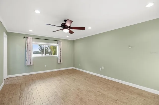 a view of a big room with wooden floor and windows