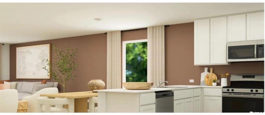 512 Runaway Train Drive Loris, SC 29569 - Photo 6 of 18 Kitchen featuring stainless steel appliances, white cabinets, light countertops, and a peninsula