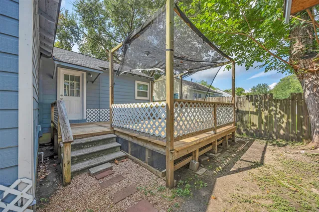 a view of a backyard with a small deck and a wooden deck