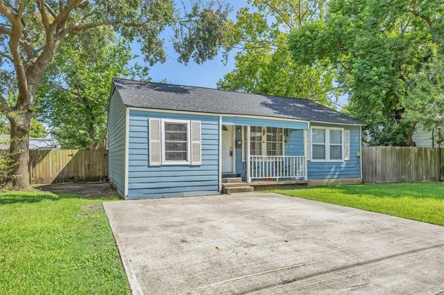 a front view of a house with a yard and trees