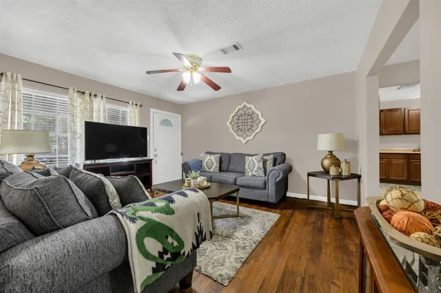 a living room with furniture a flat screen tv and kitchen view