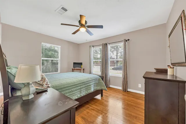 a bedroom with a bed wooden floor and window