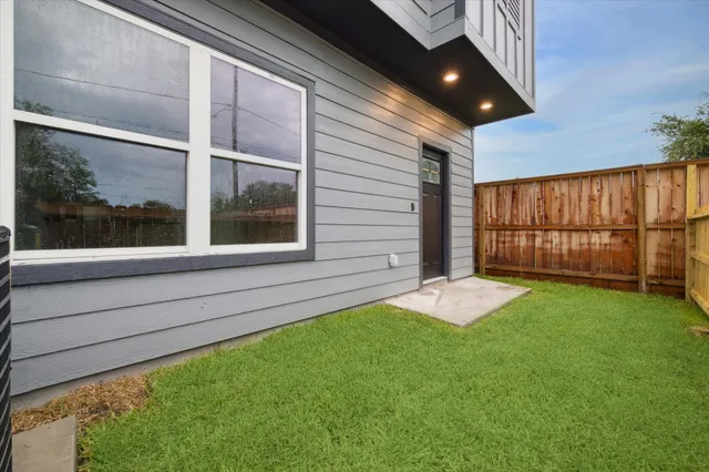 a backyard with a large window and wooden fence