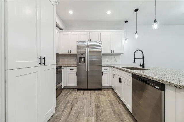 a kitchen with a sink stainless steel appliances a counter space and cabinets
