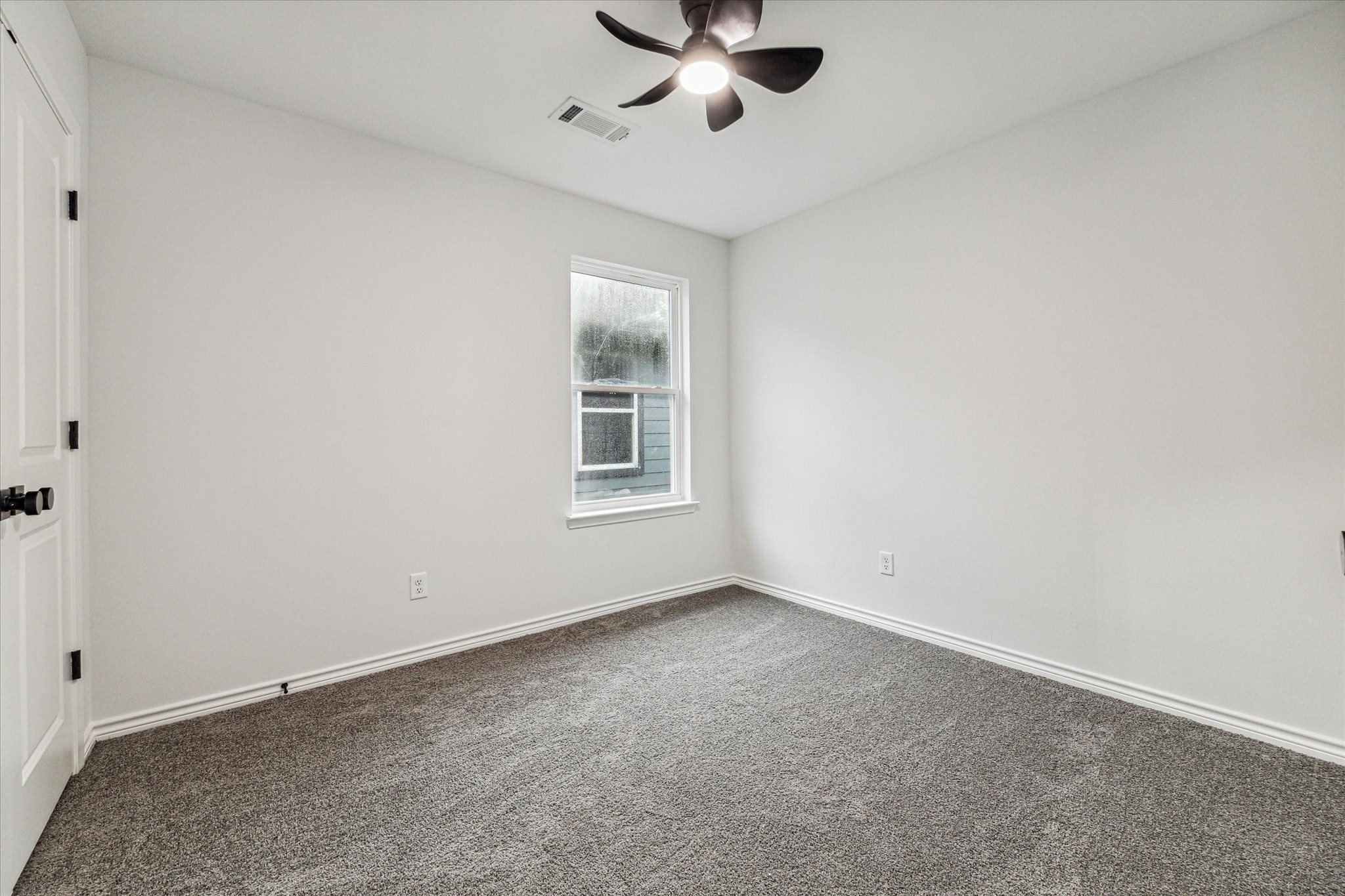 976 Marjorie Street, Unit 2 Houston, TX 77088 - Photo 7 of 11 an empty room with a window and a fan