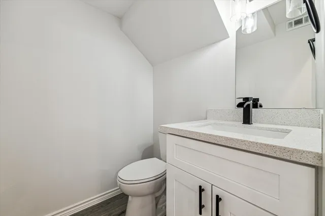 a bathroom with a granite countertop toilet and sink