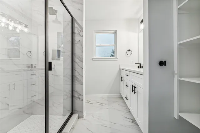 a bathroom with a double vanity sink and shower