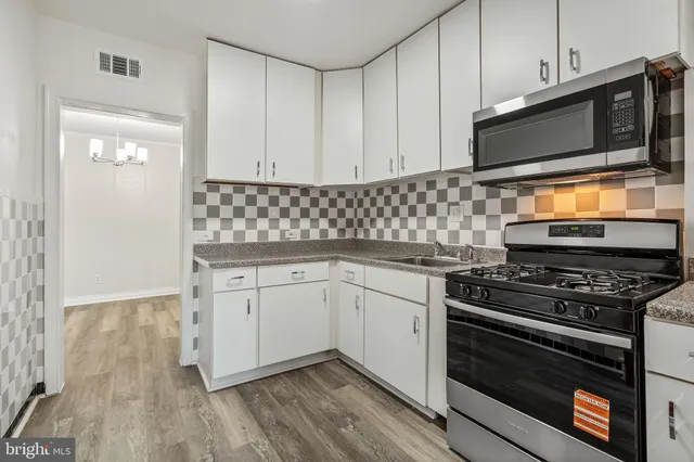 a kitchen with granite countertop cabinets stainless steel appliances and wooden floor