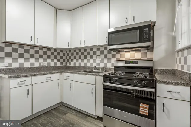 a kitchen with granite countertop white cabinets stainless steel appliances and sink