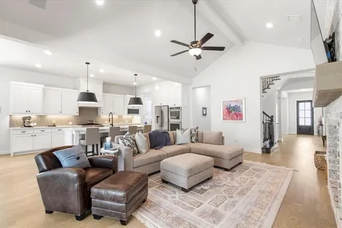 a living room with furniture kitchen view and a chandelier