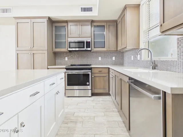 a kitchen with stainless steel appliances granite countertop a stove sink and cabinets