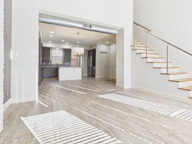 a view of a hallway with wooden floor and staircase