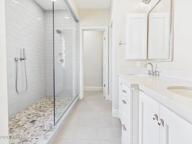 a spacious bathroom with a shower sink and mirror