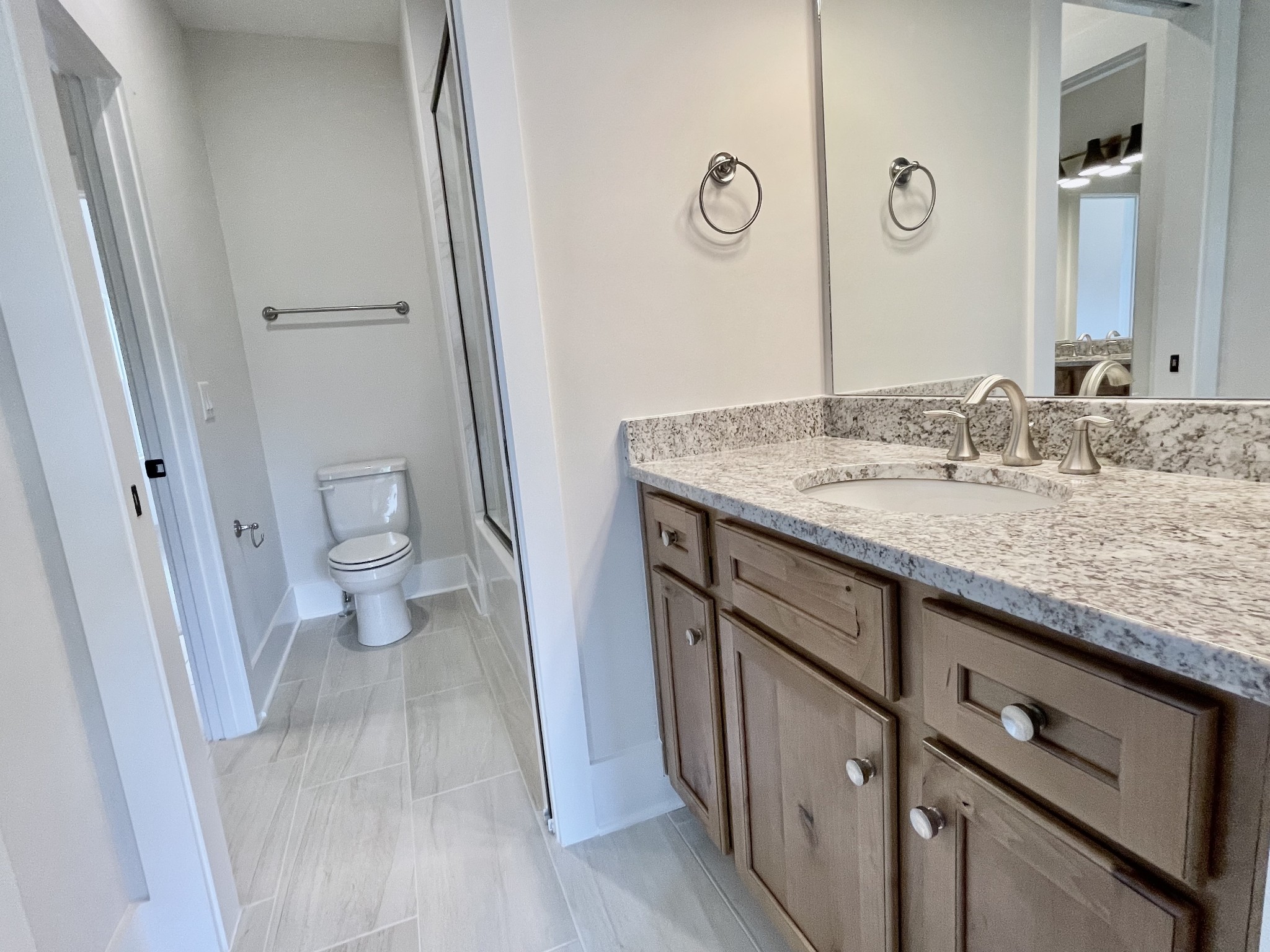 9926 Maupin Road Brentwood, TN 37027 - Photo 72 of 88 a bathroom with a granite countertop sink a toilet and a mirror