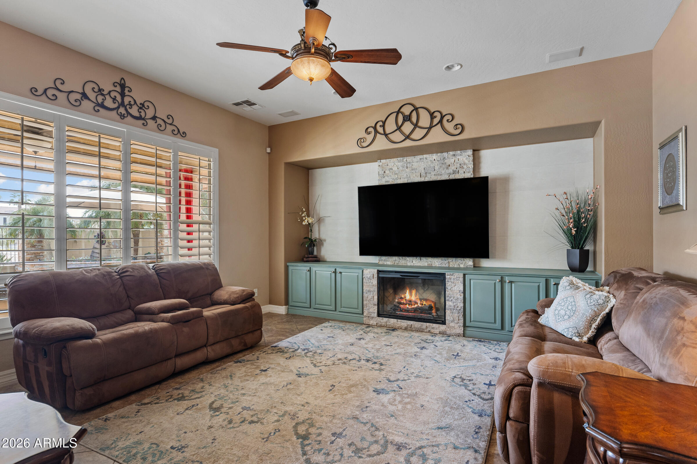 1341 East Macaw Court Gilbert, AZ 85297 - Photo 16 of 49 a living room with furniture a flat screen tv and a fireplace