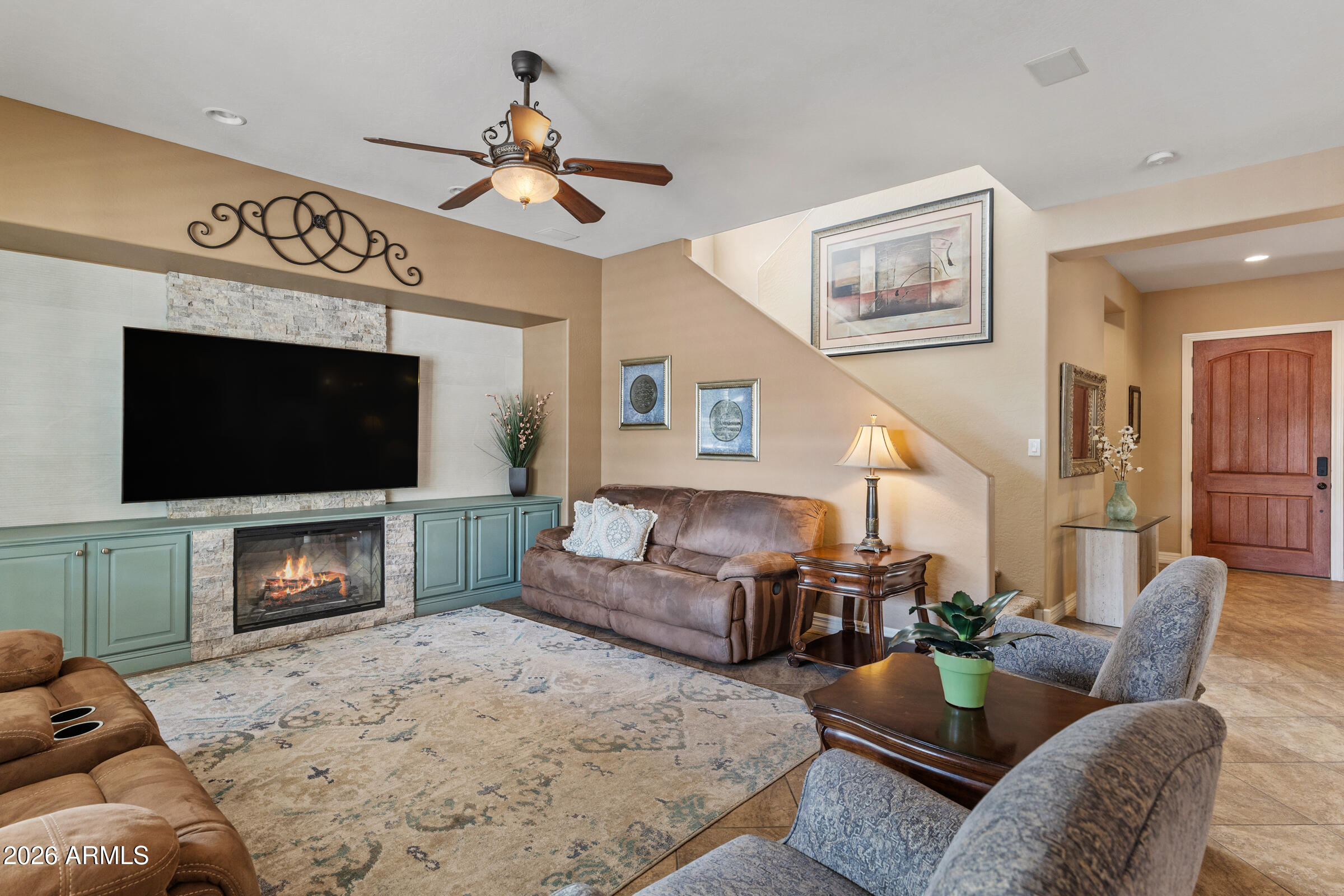 1341 East Macaw Court Gilbert, AZ 85297 - Photo 17 of 49 a living room with furniture a flat screen tv and a fireplace