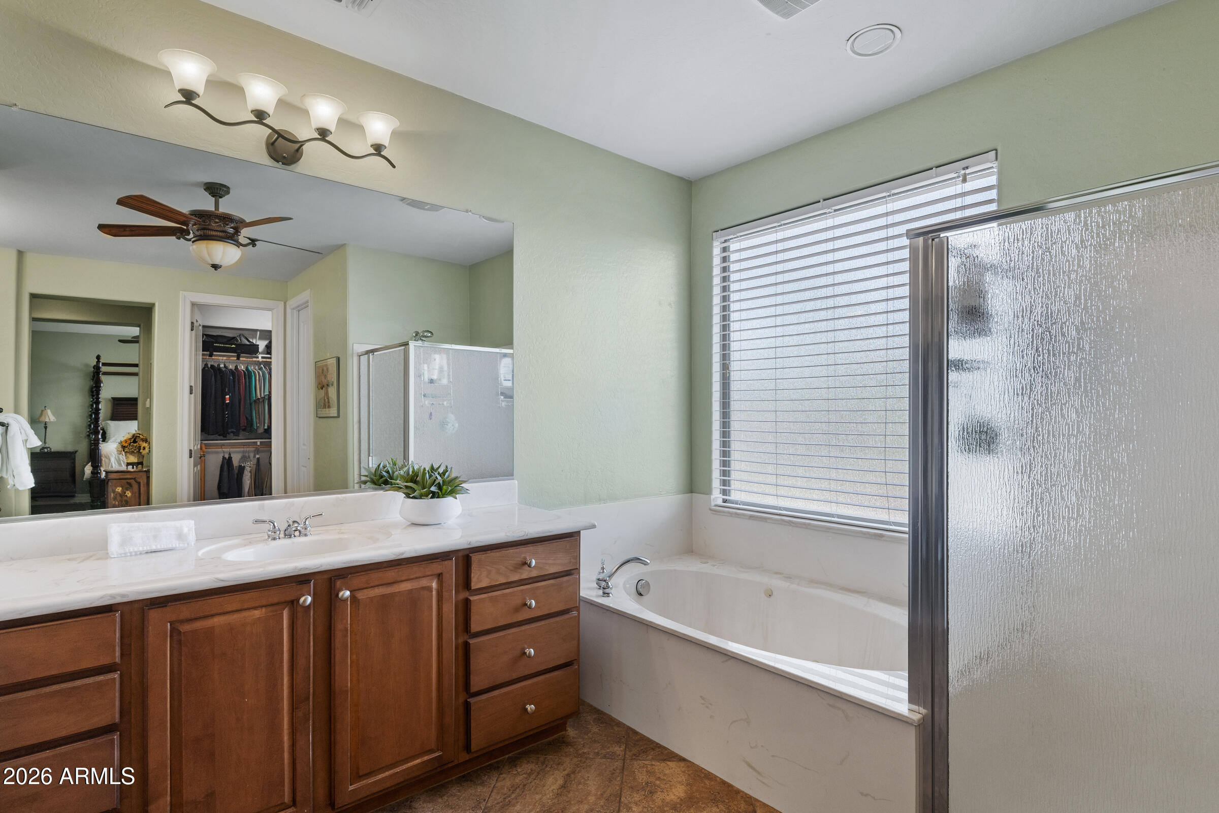 1341 East Macaw Court Gilbert, AZ 85297 - Photo 27 of 49 a bathroom with a granite countertop sink a large mirror and a bathtub