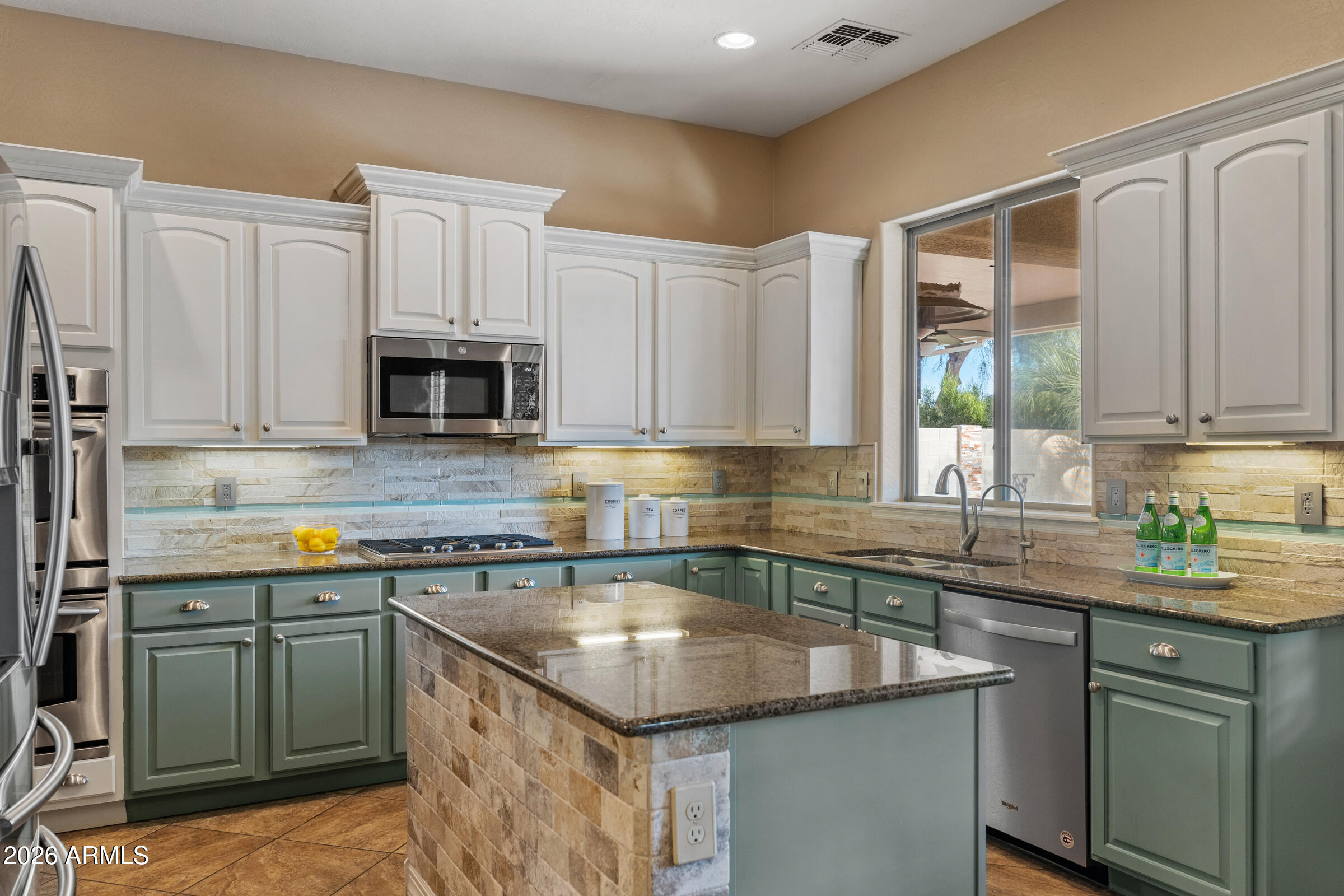1341 East Macaw Court Gilbert, AZ 85297 - Photo 10 of 49 a kitchen with stainless steel appliances granite countertop a sink stove and microwave