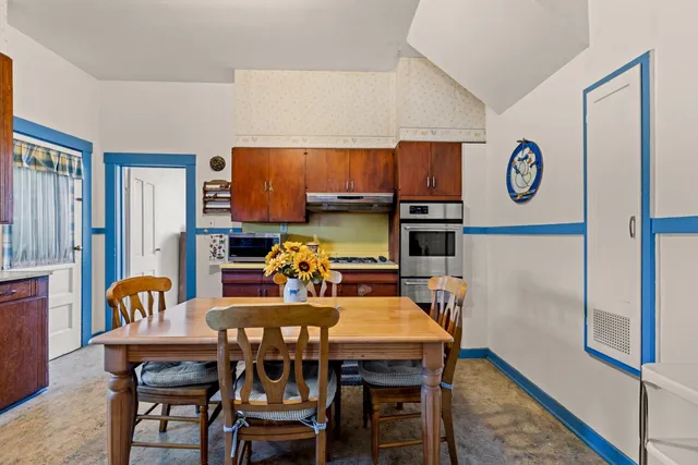 a kitchen with stainless steel appliances wooden cabinets dining table and chairs