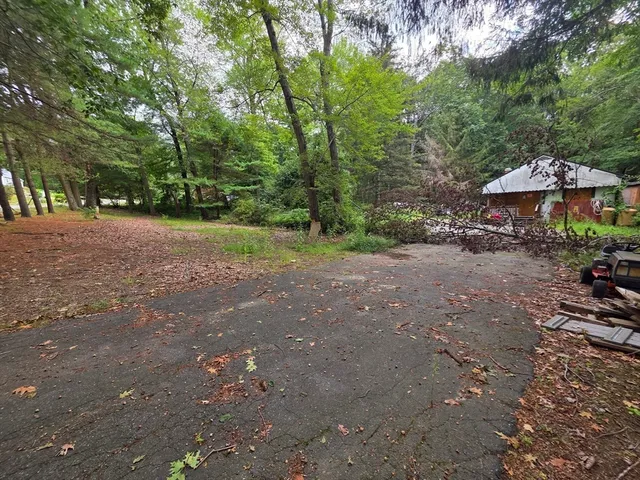 a view of a street with a bench and trees
