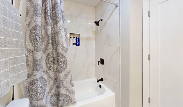 a view of a livingroom with a kitchen space with wooden floor and a window