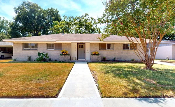 a yellow house with trees in front of it