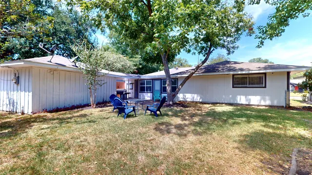 a view of a house with backyard and sitting area