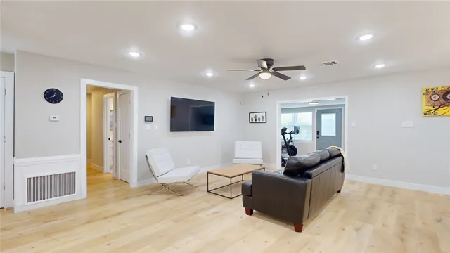 a living room with furniture and a ceiling fan
