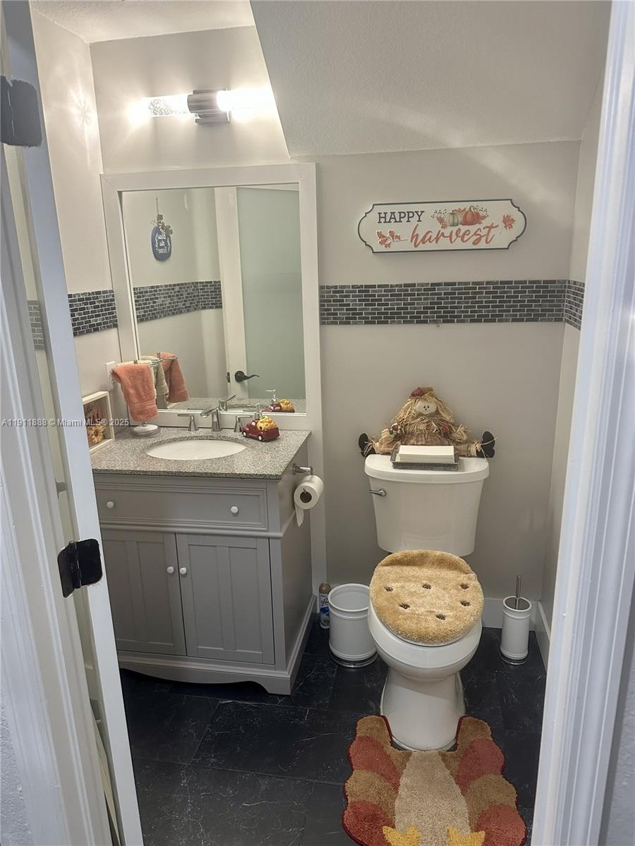 4972 Southwest 127th Avenue, Unit 4972 Miramar, FL 33027 - Photo 4 of 4 a bathroom with a toilet sink and mirror