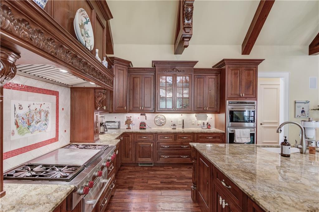 5004 Gunnison Trace Suwanee, GA 30024 - Photo 37 of 108 a kitchen with stainless steel appliances granite countertop a stove a sink and a stove
