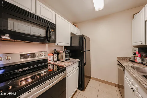a kitchen with stainless steel appliances and chandelier