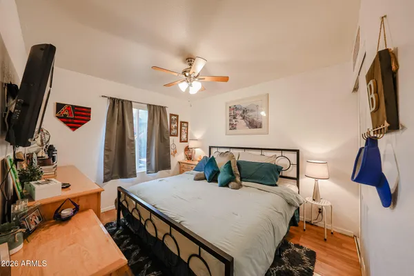 a bedroom with a bed a flat screen tv and dresser