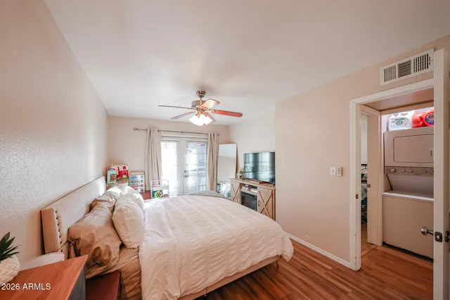 a very nice looking room with a large bed tv and wooden floor