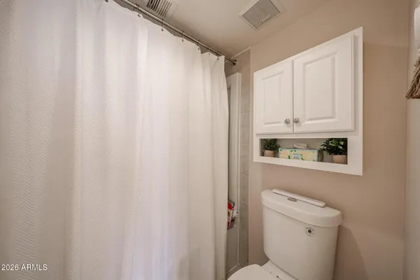 a bathroom with a toilet and shower curtain