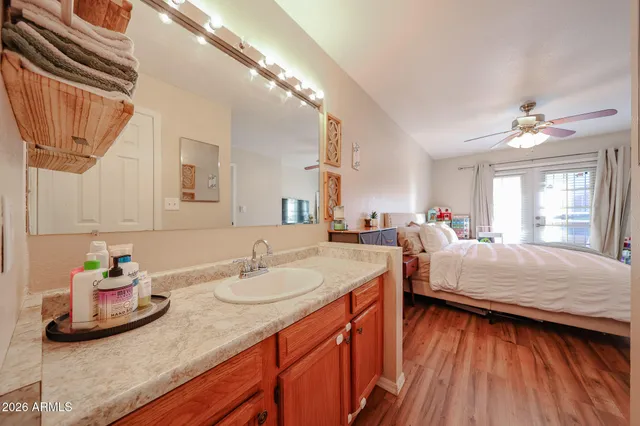 a en suite bathroom with a granite countertop sink and a mirror