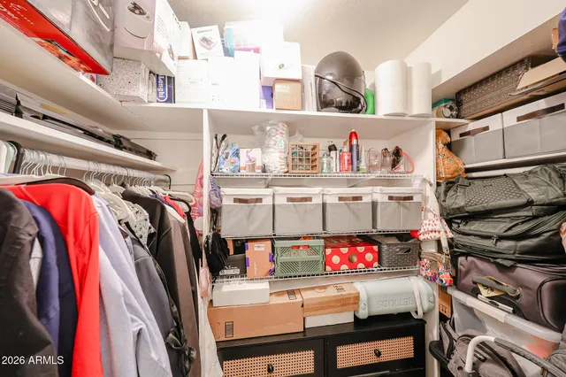 a view of walk in closet with clothes and shoes